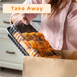 Mulher colocando embalagem com comida pronta em uma sacola de papel, ilustrando serviço de comida para viagem (take away).